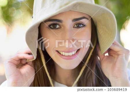 Face, smile and close up of woman with hat or lady with natural beauty on a sunny day or hiker on bokeh background. Head cap, portrait and happy female tourist or summer leisure and recreation Face, smile and close up of woman with hat or lady with natural beauty on a sunny day or hiker on bokeh background. Head cap, portrait and happy female tourist or summer leisure and recreation 103689419