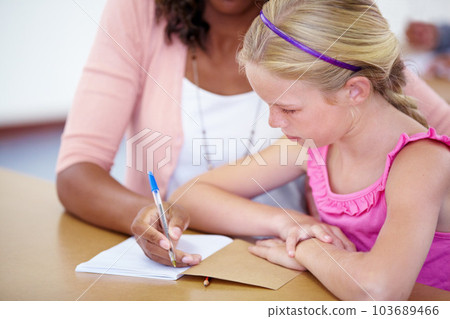 Everyone does well with a little help. a teacher helping a pupil out with her schoolwork. 103689466