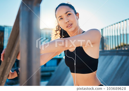Shes ready for a workout. Cropped shot of an attractive young female athlete warming up before beginning her run in the city. 103689628