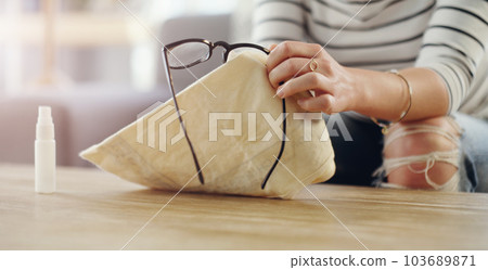 Hand, woman cleaning glasses and spray with chemical liquid, cloth and hygiene with lens maintenance. Clean spectacles, eyewear and female cleaner at home with eye care and disinfectant bottle Hand, woman cleaning glasses and spray with chemical liquid, cloth and hygiene with lens maintenance. Clean spectacles, eyewear and female cleaner at home with eye care and disinfectant bottle 103689871