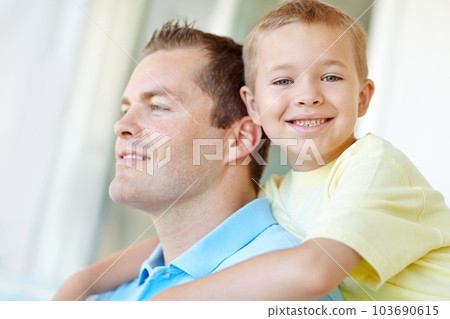 Hugging his dad. Cute, young boy smiling at the camera while hugging his father. Hugging his dad. Cute, young boy smiling at the camera while hugging his father. 103690615