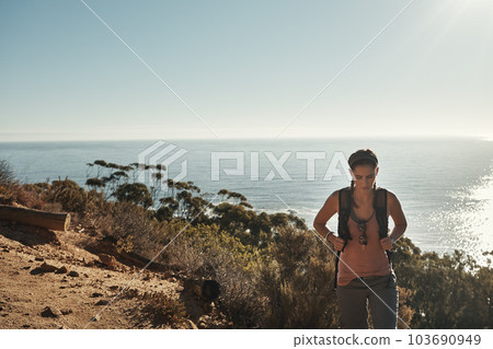 Time to set off on an adventure. a young woman out on a hike through the mountains. 103690949