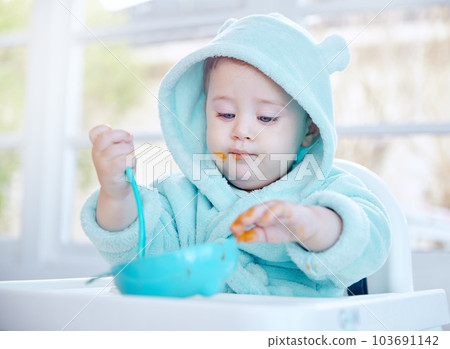 Theres no better way to start the day. Shot of an adorable baby boy eating his food. 103691142