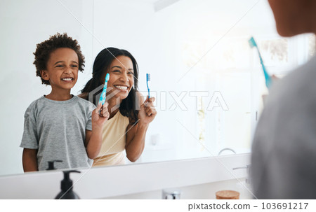Teaching, mama and son brushing teeth, wellness and cleaning mouth at home, bathroom and smile. Family, female parent and mother with male child, kid and boy with reflection, health or dental hygiene 103691217