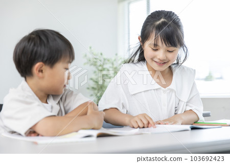 Older sister teaching her little bro 103692423