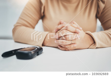 Hands, anxiety and diabetes with a woman waiting for the results of a test while sitting at a table. Healthcare, blood and equipment with a female diabetic testing her sugar or glucose level 103692669