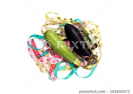 Zucchini with eggplant on measuring tape on white background. 103692673