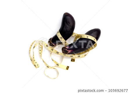 Measuring tape around eggplant on white background. Measuring tape around eggplant on white background. 103692677