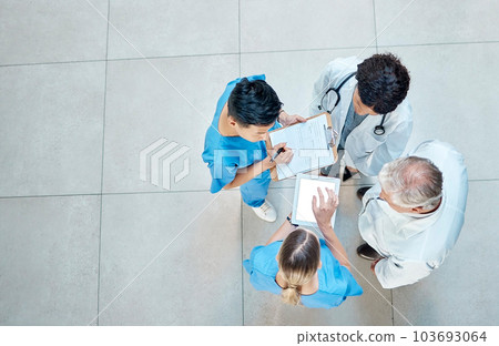 Healthcare, doctors and group meeting with a tablet for discussion, planning or research. Above men and women medical staff talking about team collaboration, online schedule or surgery in a hospital Healthcare, doctors and group meeting with a tablet for discussion, planning or research. Above men and women medical staff talking about team collaboration, online schedule or surgery in a hospital 103693064