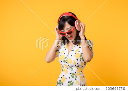 Smile pretty asian model person listen music song and enjoy dance with wireless headphone online audio radio sound. Positive fun exited joyful youth female woman on yellow isolated background studio Smile pretty asian model person listen music song and enjoy dance with wireless headphone online audio radio sound. Positive fun exited joyful youth female woman on yellow isolated background studio 103693758