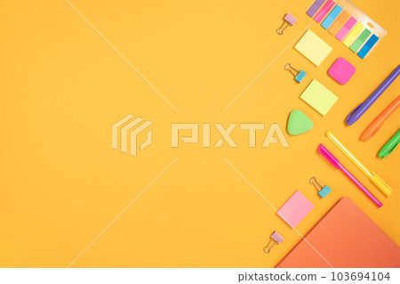 Frame of colorful school and office stationery set on yellow background. Flatly. Frame of colorful school and office stationery set on yellow background. Flatly. 103694104