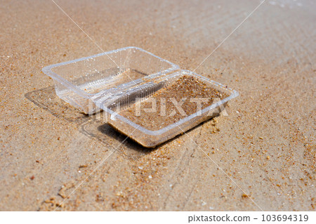 Plastic food container on the beach 103694319