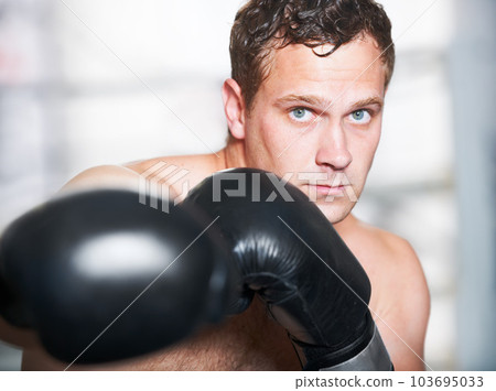 Professional boxer. A young handsome boxer throwing a punch at the camera. Professional boxer. A young handsome boxer throwing a punch at the camera. 103695033