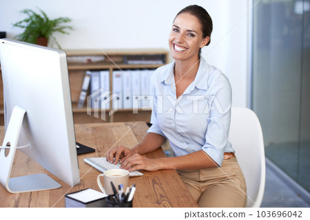 Portrait, happy woman and typing at computer in office for business management, internet and technology. Female worker at desktop pc for web planning, online research and professional administration 103696042