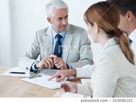 The weekly board room meeting has started. a group of colleagues having a meeting in the boardroom. 103696101