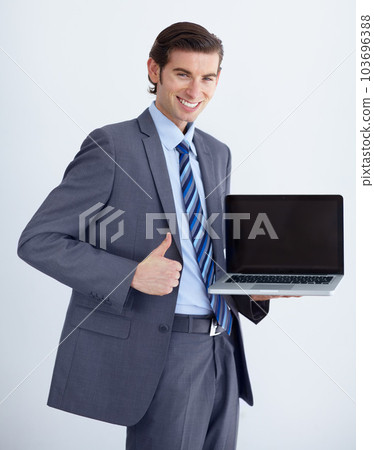 Invaluable business tool. A young businessman endorsing a laptop with a thumbs up. 103696388