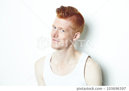 Happy, ginger and portrait of man in studio for casual, red hair and trendy style. Natural, smile and shy with face of male model isolated on white background for confident, pride or mockup 103696397