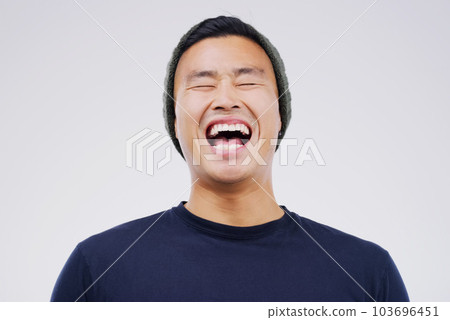 Happy, laughing and man in studio with a casual outfit excited for a comic joke or funny story. Happiness, smile and face of an Asian male person with a positive facial expression by white background 103696451