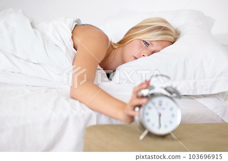 It cant be that time already...A young woman putting her alarm clock off in the morning. 103696915