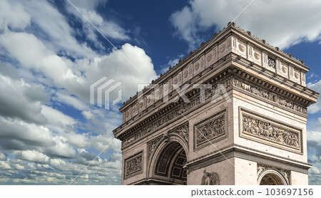 Arc de Triomphe (against the background of sky with clouds), Paris, France. The walls of the arch are engraved with the names of 128 battles and names of 660 French military leaders (in French) 103697156
