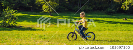 Happy kid boy of 5 years having fun in the park with a bicycle on beautiful day BANNER, LONG FORMAT 103697300