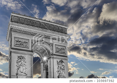 Arc de Triomphe (against the background of sky with clouds), Paris, France. The walls of the arch are engraved with the names of 128 battles and names of 660 French military leaders (in French) 103697392