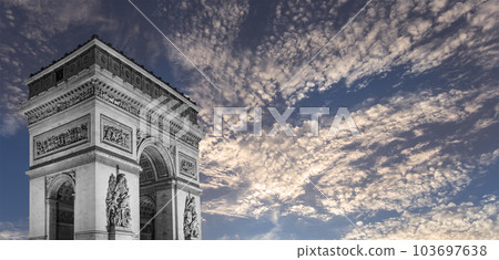 Arc de Triomphe (against the background of sky with clouds), Paris, France. The walls of the arch are engraved with the names of 128 battles and names of 660 French military leaders (in French) 103697638