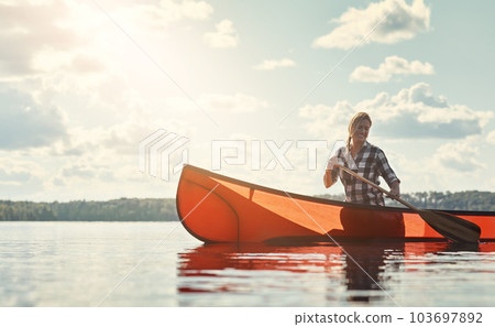 This is how she does weekends. an attractive young woman spending a day kayaking on the lake. 103697892