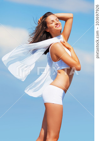 Wind, model and woman in underwear is happy, excited and healthy outdoors with a cloth or scarf as style. Body, freedom and young female person in summer with happiness isolated in a blue sky Wind, model and woman in underwear is happy, excited and healthy outdoors with a cloth or scarf as style. Body, freedom and young female person in summer with happiness isolated in a blue sky 103697926