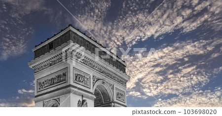 Arc de Triomphe (against the background of sky with clouds), Paris, France. The walls of the arch are engraved with the names of 128 battles and names of 660 French military leaders (in French) 103698020