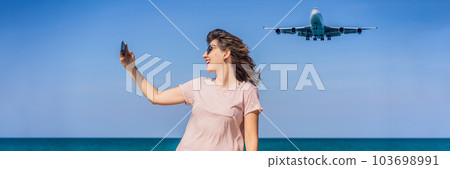 Woman makes a selfie on the beach watching the landing planes. Traveling on an airplane concept. Text space. Island Phuket in Thailand. Impressive paradise. Hot beach Mai Khao. Amazing landscape Woman makes a selfie on the beach watching the landing planes. Traveling on an airplane concept. Text space. Island Phuket in Thailand. Impressive paradise. Hot beach Mai Khao. Amazing landscape 103698991