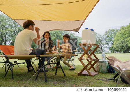 在防水布下放鬆的家庭形象,在營地的家庭聚會 在防水布下放鬆的家庭形象,在營地的家庭聚會 103699021
