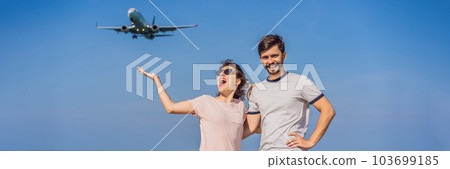 Man and woman tourists have fun on the beach watching the landing planes. Traveling on an airplane concept. Text space. Island Phuket in Thailand. Impressive paradise. Hot beach Mai Khao. Amazing 103699185