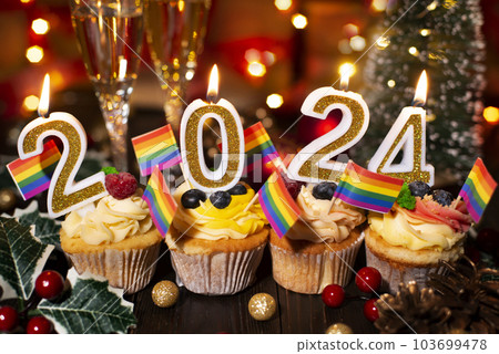 Food tray with cupcakes new year candles wineglasses and rainbow flags decorations Food tray with cupcakes new year candles wineglasses and rainbow flags decorations 103699478