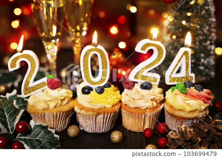 Cupcakes with new year candles and wineglasses Cupcakes with new year candles and wineglasses 103699479