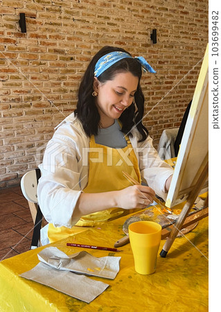 Woman with brush painting on canvas Woman with brush painting on canvas 103699482