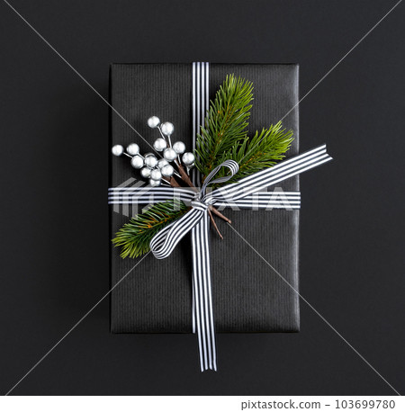 Black gift box with ribbon, spruce branches and silver berries 103699780
