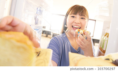 Young woman trying to open the refrigerator and take a cake Young woman trying to open the refrigerator and take a cake 103700297