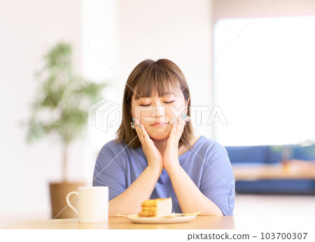 看著桌上蛋糕的年輕女人 103700307