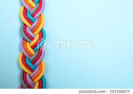 Top view of braided colorful ropes on light blue background, space for text. Unity concept Top view of braided colorful ropes on light blue background, space for text. Unity concept 103700657