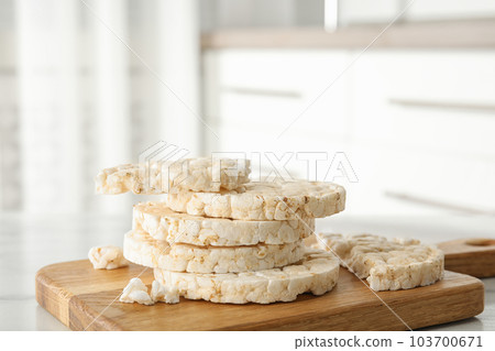 Puffed rice cakes on wooden board indoors, closeup 103700671