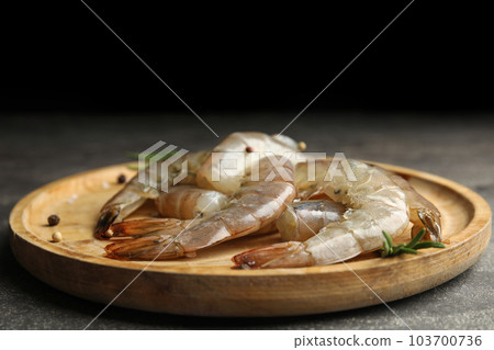 Fresh raw shrimps with rosemary on wooden board Fresh raw shrimps with rosemary on wooden board 103700736