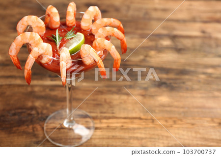 Shrimp cocktail with tomato sauce on wooden table. Space for text 103700737