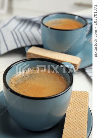 Delicious wafers and coffee for breakfast on table, closeup Delicious wafers and coffee for breakfast on table, closeup 103701372