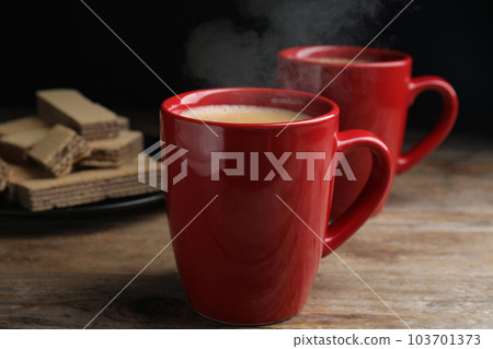 Delicious coffee and wafers on wooden table Delicious coffee and wafers on wooden table 103701373