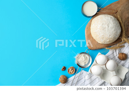 Flat lay composition with dough on blue background, space for text. Cooking pastries 103701394