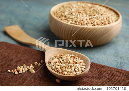 Uncooked green buckwheat grains on table, closeup Uncooked green buckwheat grains on table, closeup 103701418