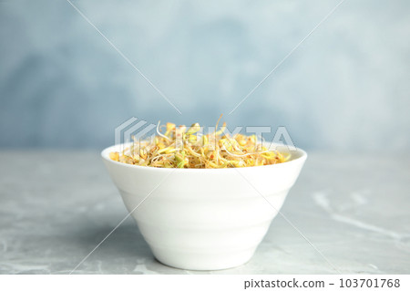 Bowl with sprouted green buckwheat on light grey table 103701768
