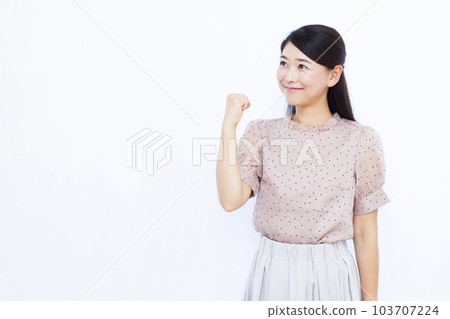 A woman in her thirties doing a guts pose in front of a white background 103707224