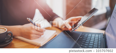 Woman sitting in cafe at the table and working on the laptop. Woman sitting in cafe at the table and working on the laptop. 103707602